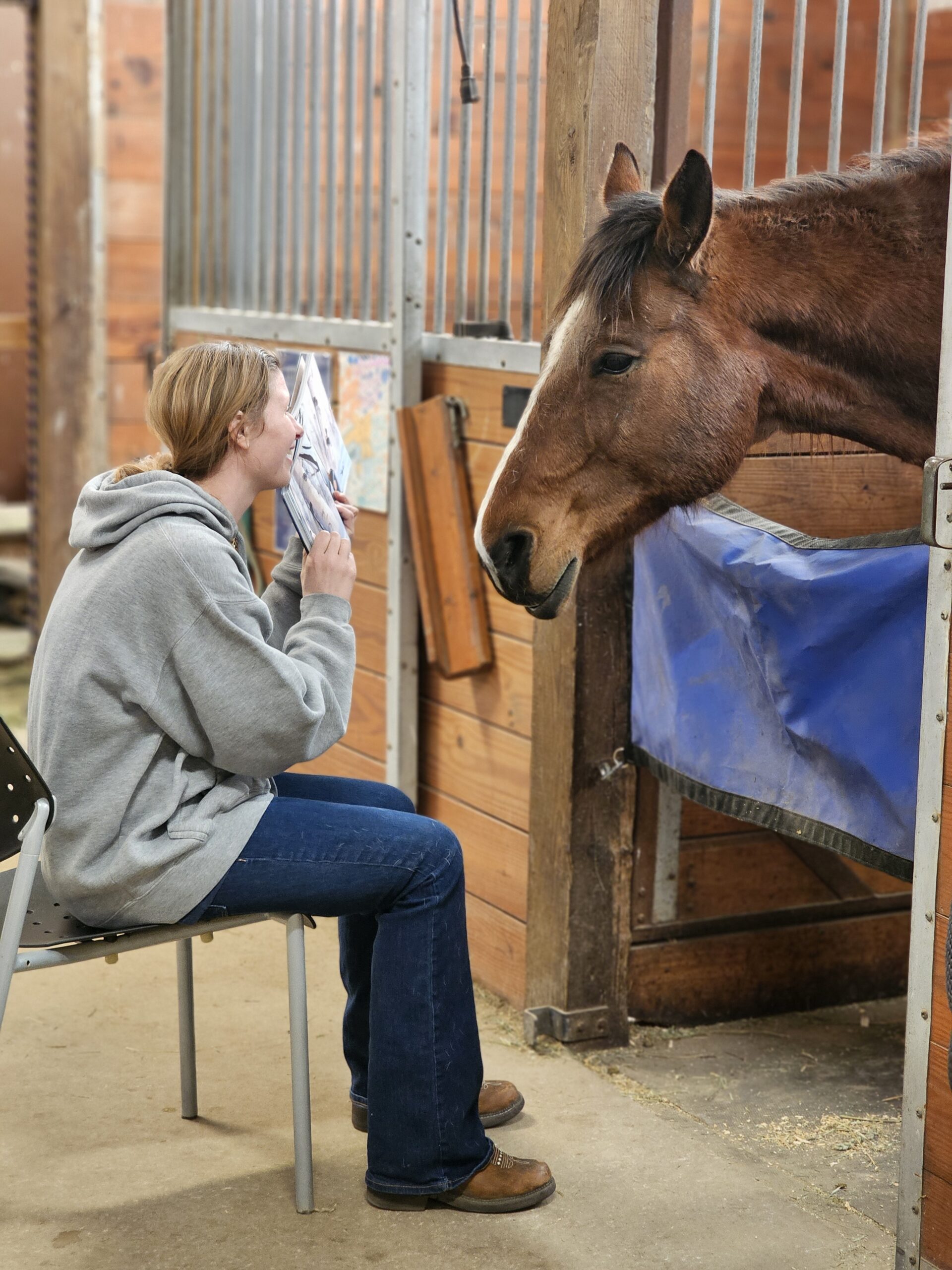 girl reading book to a horse