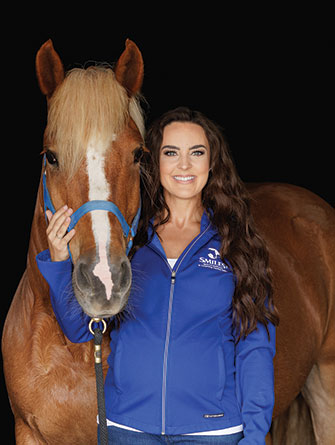 Woman standing with horse