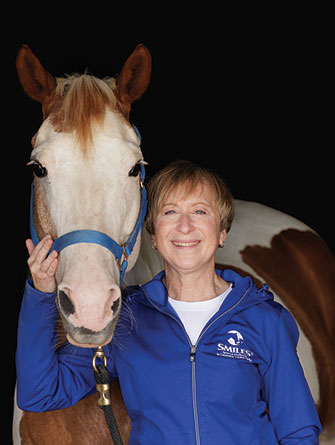 Woman standing with horse